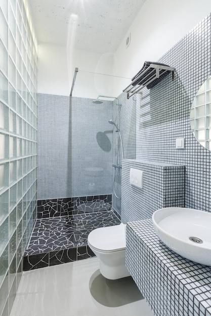 Intérieur de salle de bains blanc moderne avec de petits carreaux de céramique moÑ‹aic carrés. Design d'intérieur de salle de bain contemporain