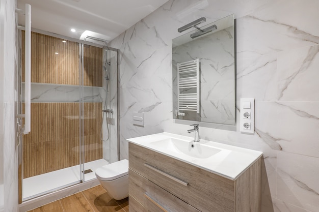 Intérieur de salle de bains rénovée moderne avec douche avec finition en bois