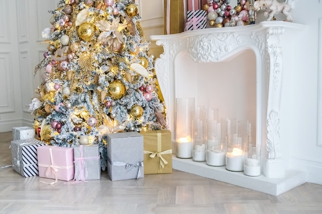 Intérieur de la salle blanche avec arbre du Nouvel An décoré, présentoirs et cheminée