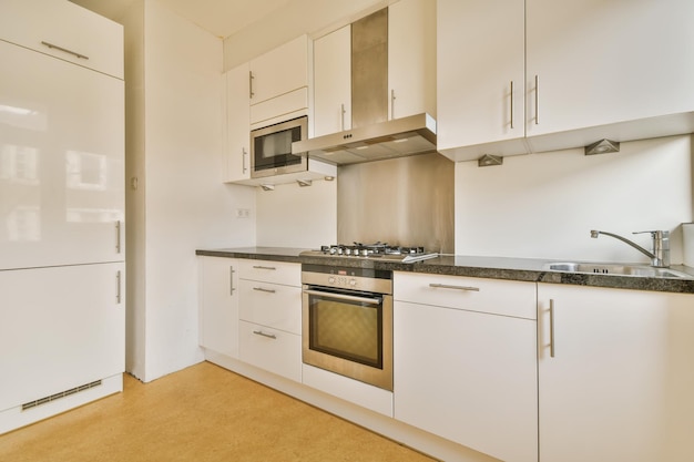 Intérieur d'une salle de cuisine moderne et élégante avec des armoires blanches et un réfrigérateur blanc