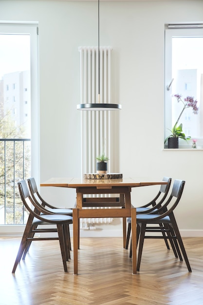 Intérieur de salle à manger scandinave élégant avec table et chaises de famille design et accessoires