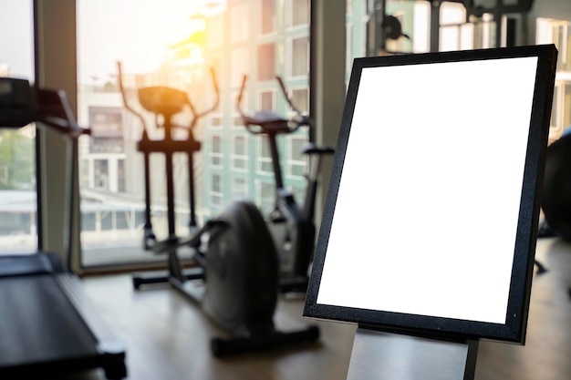 Photo intérieur de salle de sport moderne avec affiche blanche vide sur l'équipement mural et vue sur la ville concept de santé et de style de vie maquette