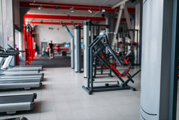 Intérieur de la salle de sport, personne, machines d'exercice et équipement sportif dans un club de remise en forme