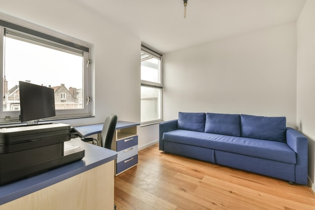 L'intérieur de la salle de travail aux couleurs vives avec un ordinateur et un canapé sur parquet