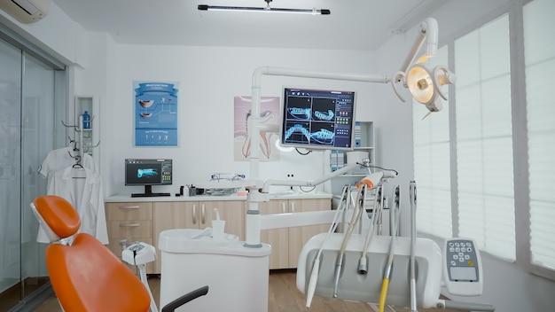 Intérieur de la salle vide de bureau d'orthodontiste de stomatologie équipée de rayons X sur des moniteurs