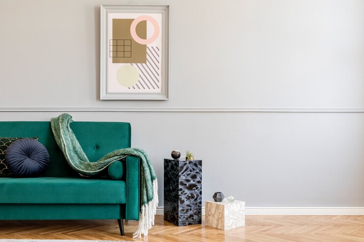 Photo intérieur de salon élégant et luxueux avec fauteuil vert élégant, tables rétro, lampes design, accessoires chics, miroir doré et cadres fictifs sur le mur gris mouluré. modèle.