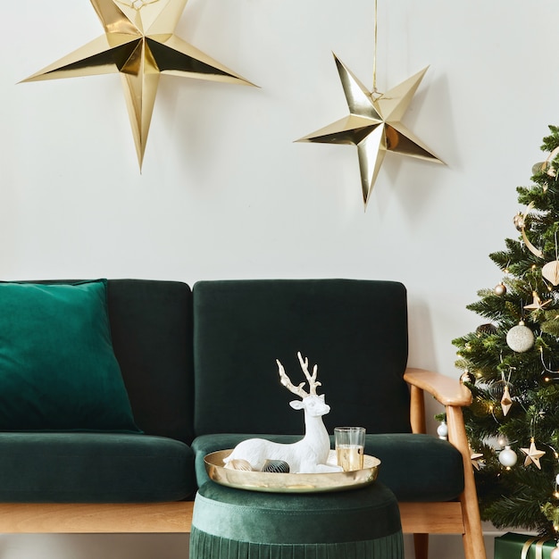 Intérieur de salon de noël élégant avec canapé vert, cheminée blanche, arbre de noël et couronne, étoiles, cadeaux et décoration. Du temps en famille. Modèle.