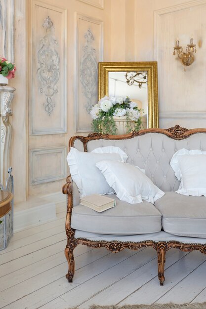 Intérieur de salon riche et luxueux de couleur pastel beige avec des meubles anciens et coûteux de style baroque. murs décorés de stuc et de fresques