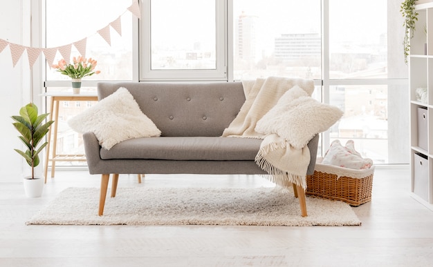 Intérieur de salon scandinave avec canapé gris et fenêtres panoramiques