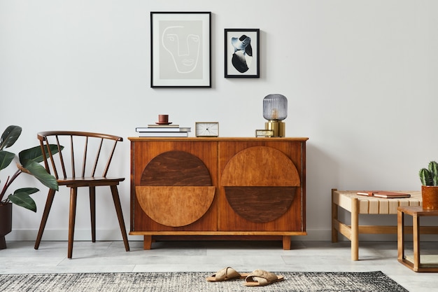 Intérieur de salon scandinave rétro élégant avec commode en bois, cadres, chaise, tabouret design, cactus, lampe, horloge, livre, décoration et accessoires personnels dans la décoration intérieure.