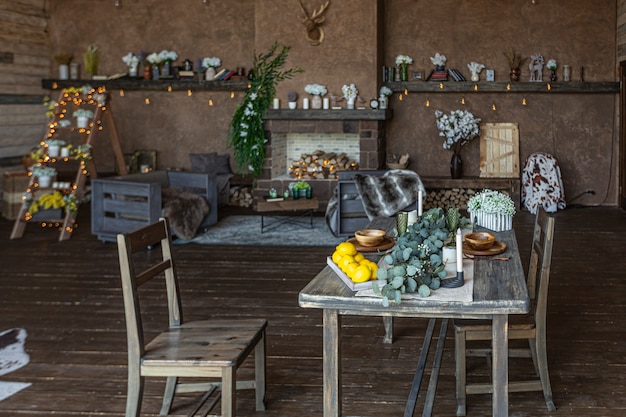 Intérieur sombre et confortable d'une grande maison en bois de campagne, de meubles en bois et de fourrures d'animaux. immense baie vitrée et très haut plafond.