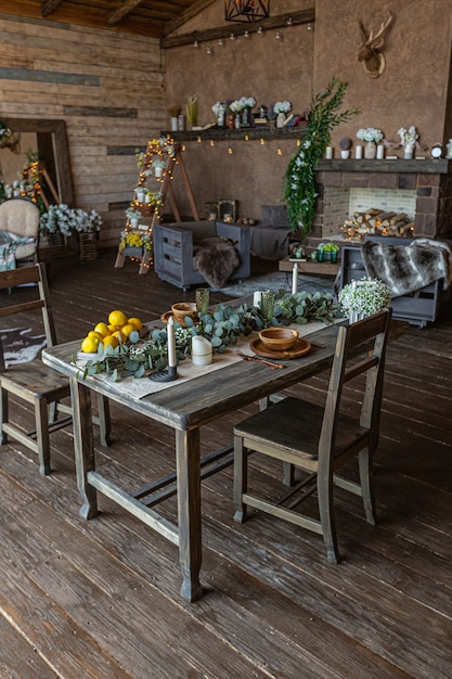 Intérieur sombre et confortable d'une grande maison en bois de campagne, de meubles en bois et de fourrures d'animaux. immense baie vitrée et très haut plafond.