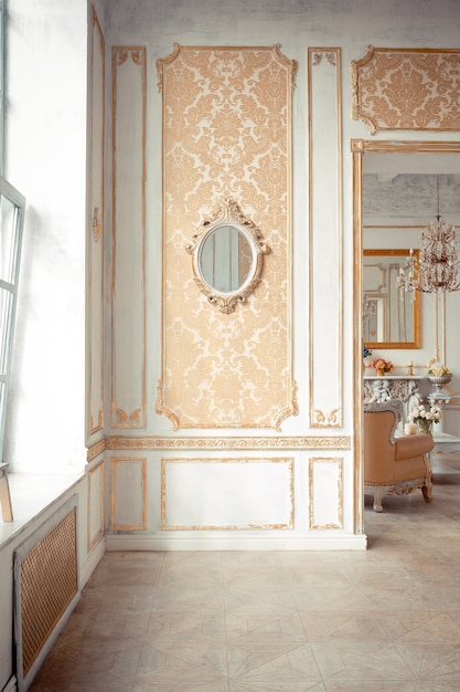 Intérieur très riche de l'appartement avec des décorations dorées sur les murs dans le style baroque et des meubles de luxe avec de la peinture dorée.