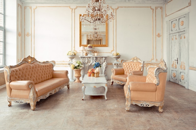 Intérieur très riche de l'appartement avec des décorations dorées sur les murs dans le style baroque et des meubles de luxe avec de la peinture dorée.