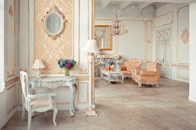 Intérieur très riche de l'appartement avec des décorations dorées sur les murs dans le style baroque et des meubles de luxe avec de la peinture dorée.