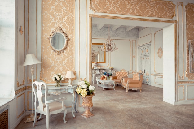 Intérieur très riche de l'appartement avec des décorations dorées sur les murs dans le style baroque et des meubles de luxe avec de la peinture dorée.