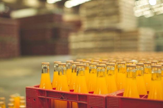 Intérieur de l'usine de boissons. Convoyeur coulant avec des bouteilles de jus ou d'eau.