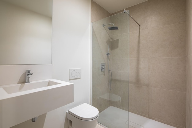Intérieur vide d'une salle de bain blanche moderne avec toilette lavabo miroir et douche avec cloison en verre