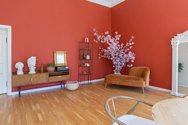 Intérieur vintage antique dans un salon de style XIXe siècle avec murs rouge vif, parquet et lumière directe du soleil à l'intérieur de la pièce.