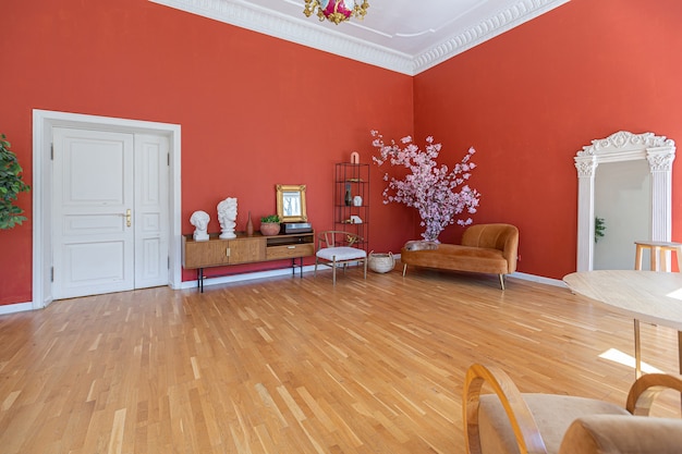 Intérieur vintage antique dans un salon de style XIXe siècle avec murs rouge vif, parquet et lumière directe du soleil à l'intérieur de la pièce.