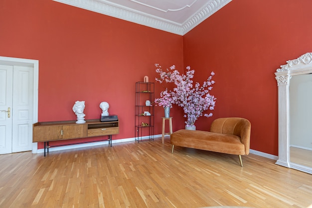 Intérieur vintage antique dans un salon de style XIXe siècle avec murs rouge vif, parquet et lumière directe du soleil à l'intérieur de la pièce.