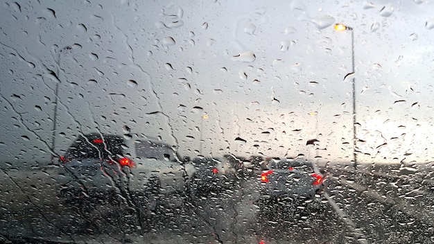 À l'intérieur de la voiture. Libre de gouttes d'eau de pluie. vue sur le pare-brise de la voiture pendant les jours de pluie sur l'autoroute le soir