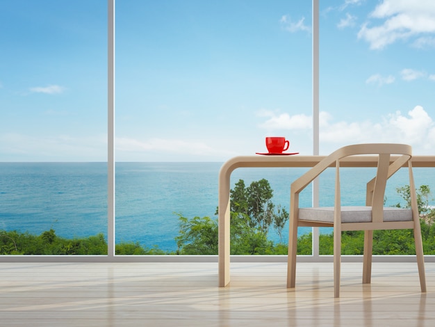 Photo intérieur vue mer du bureau à domicile avec une tasse de café rouge.