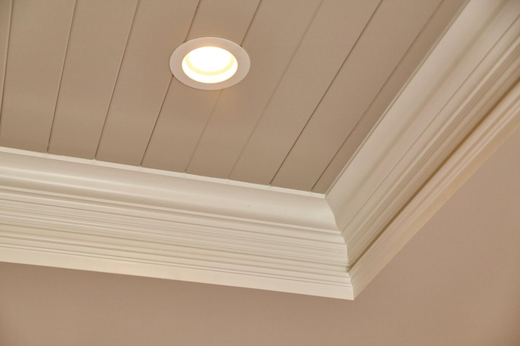Photo des intérieurs modernes avec des panneaux de plafond élégants et un éclairage ambiant