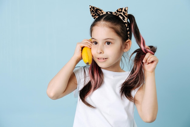 Interpolation hilarante avec des oreilles de chat pressant la banane contre son oreille comme un téléphone