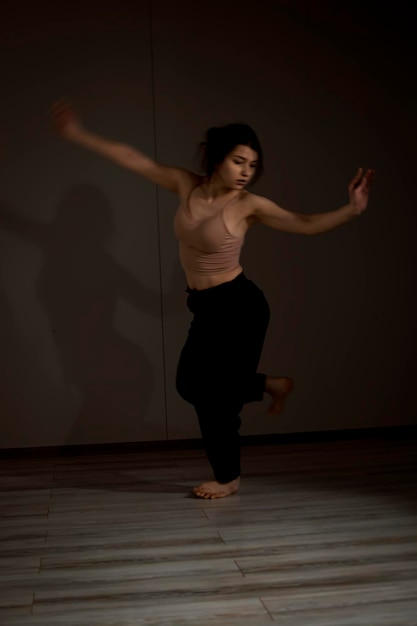 Interprète de danse flexible mince lors d'une pratique de danse en studio moderne