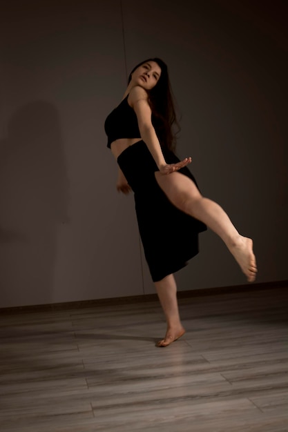 Interprète de danse flexible mince lors d'une pratique de danse en studio moderne