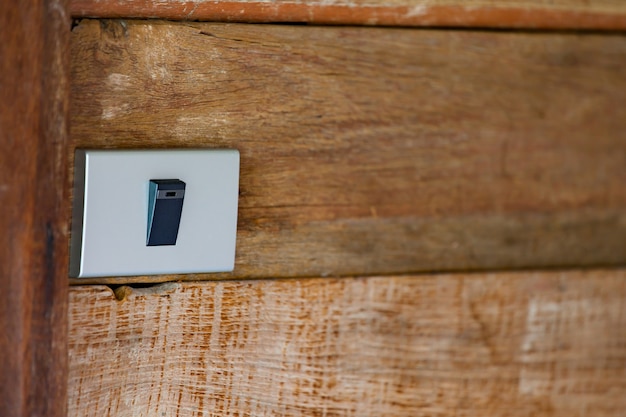Interrupteur d&#39;éclairage électrique à bascule traditionnel blanc en position Off sur le mur en bois