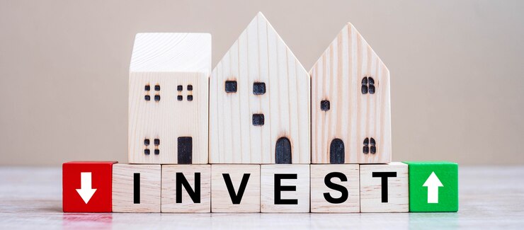 Photo investir des cubes avec un modèle de maison en bois sur fond de table.