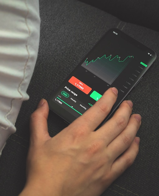 Investisseur analysant le graphique boursier sur téléphone mobile. Écran avec graphiques financiers, photo conceptuelle de trading et d'échange