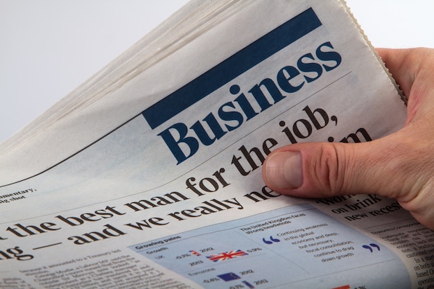 Investisseur détenant et lisant le dernier journal de l'entreprise.