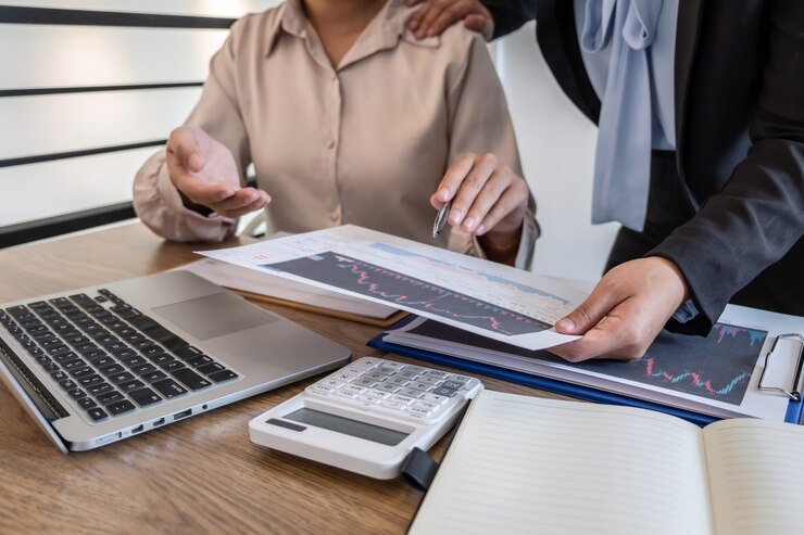 Investisseur femme d'affaires lors d'une réunion ayant planifié et analysé la coopération des partenaires dans un projet de marketing commercial d'investissement et pointant sur les données présentées et négociant une bourse à profit.