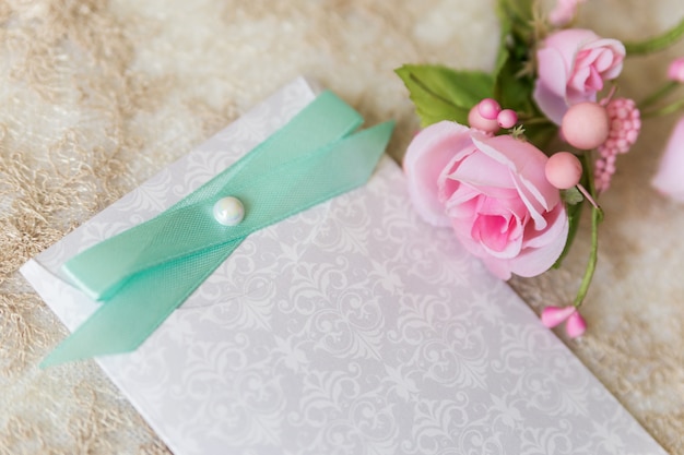 Invitation de mariage avec ruban vert clair et roses roses