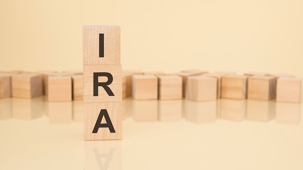 Ira acronyme de blocs de bois avec des lettres concept de compte de retraite individuel sur fond jaune copie espace disponible