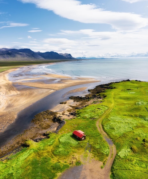 Islande Vue aérienne sur le seul champ de maison et la côte de l'océan Paysage panoramique en Islande le jour Paysage depuis un drone