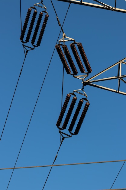 Isolateurs de ligne électrique sur un ciel bleu