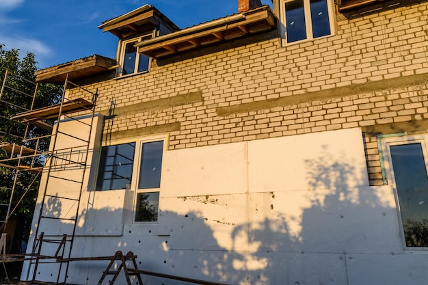 Isolation de la maison avec échafaudage en polystyrène sur bâtiment