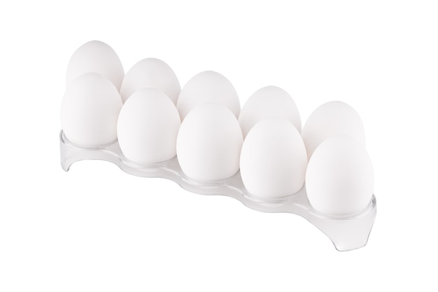 Photo isolé sur blanc pile d'oeufs de poule au support en plastique.