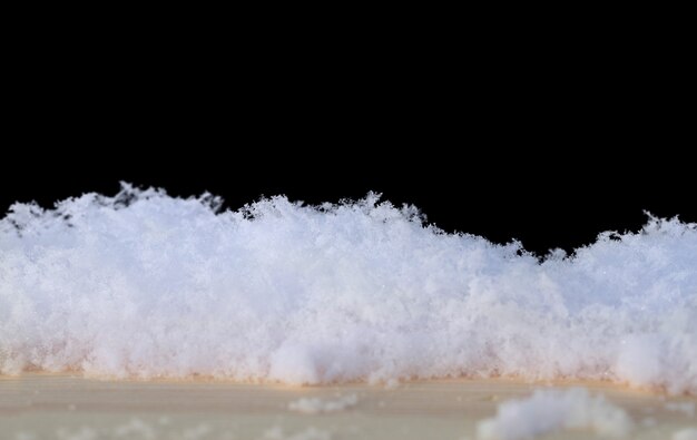 Isoler la neige blanche en fond de lumière du jour sur fond noir