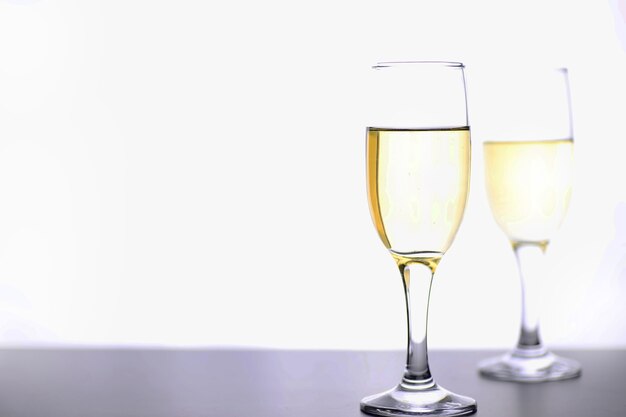 Isoler le verre de vin blanc sur une table sur un fond blanc