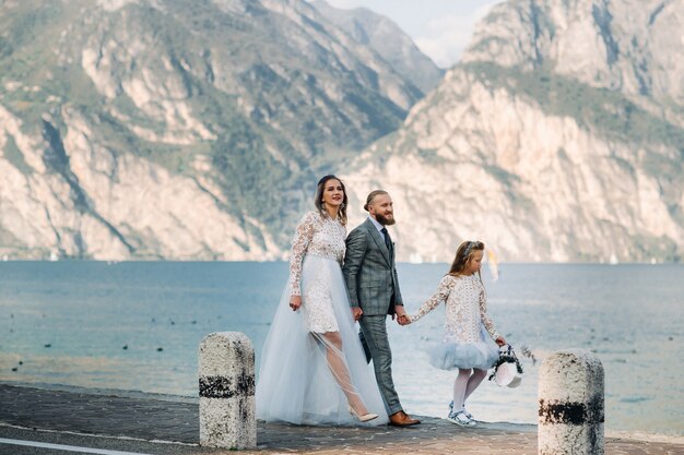 Italie, Lac de Garde. Belle famille au bord du lac de Garde en Italie au pied des Alpes. Père, mère et fille en Italie