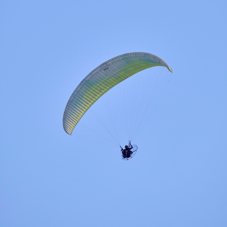 Photo italie; sicile, un homme volant sur un parapente motorisé