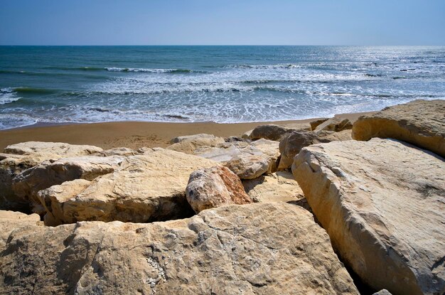 Photo italie, sicile, mer méditerranée, côte sablonneuse du sud-est, pierres brise-lames sur la plage de caucana (province de raguse)