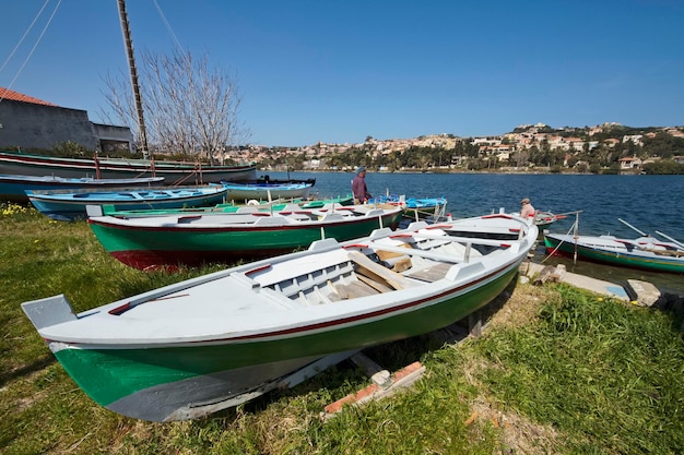 Photo italie, sicile, messine, lac ganzirri, pêcheurs et bateaux de pêche en bois à terre