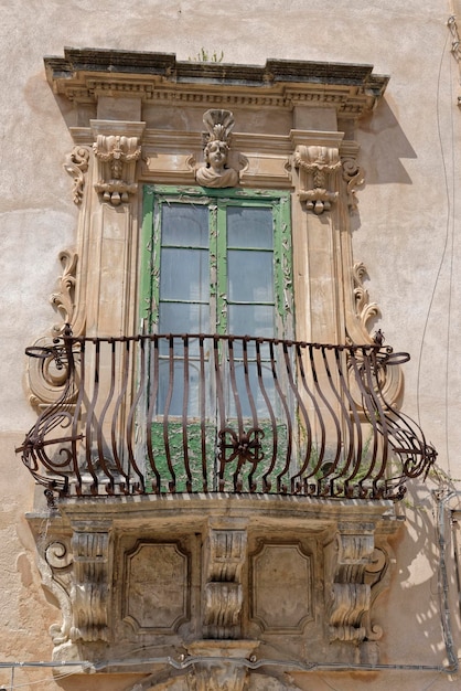 Italie, Sicile, Scicli (province de Raguse), la façade baroque et le balcon d'un immeuble ancien