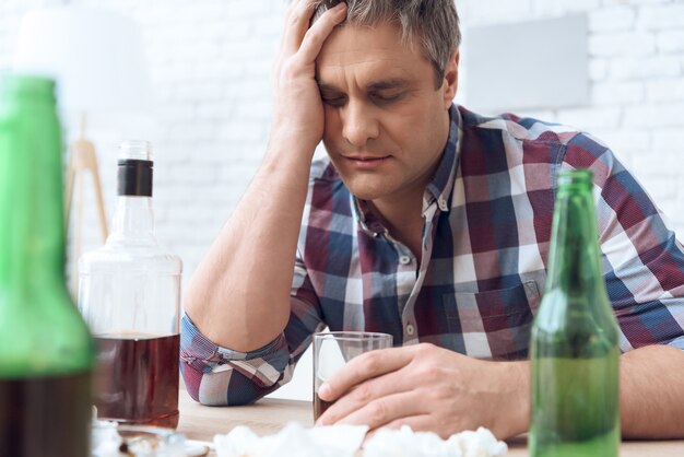 Ivre père est assis à table avec verre